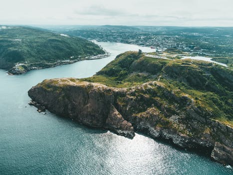 Stunning drone view of coastal cliffs and bay in summer sunshine.