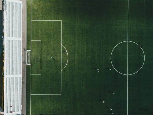 Free A top-down view of a soccer field with players in action, showcasing the vibrant green grass and sports markings. Stock Photo