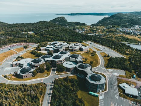 Aerial view of a unique architectural complex surrounded by lush greenery and scenic mountains.