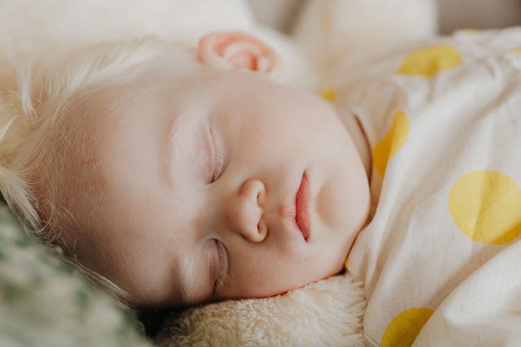 A Baby In Polka Dots Dress Sleeping