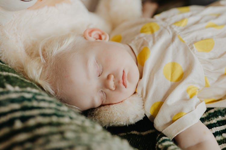 Baby In White And Yellow Polka Dot Dress Sleeping