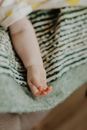 Babys Arm on White and Green Stripped Textile
