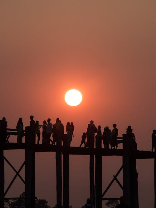 Silhouette of People on Wooden Dock During Sunset