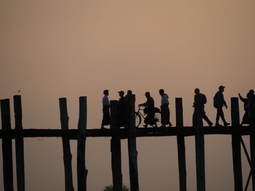 Free Silhouettes of people walking on U Bein Bridge during a beautiful sunset in Mandalay, Myanmar. Stock Photo