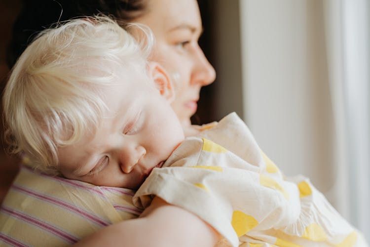 Little Girl Sleeping On Mother Shoulder