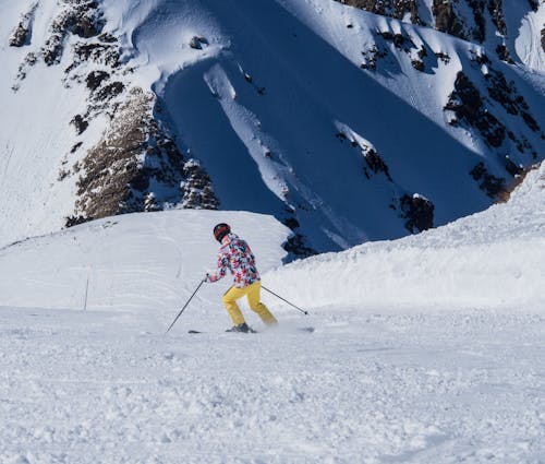 Person Skiing on Snow Covered Mountains