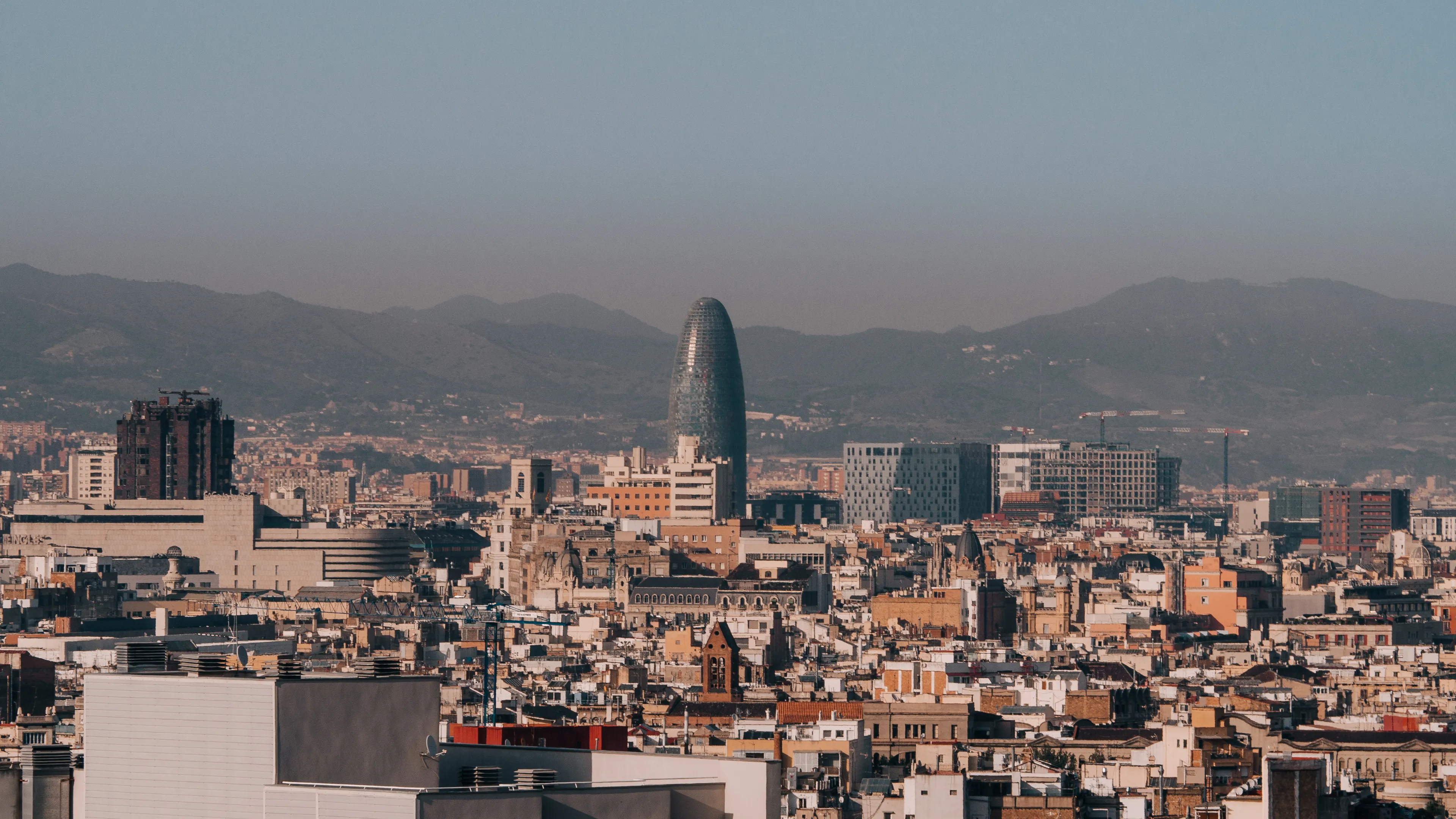 A panoramic view of Barcelona's skyline with Torre Glòries during a clear morning.