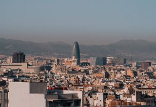 A panoramic view of Barcelona's skyline with Torre Glòries during a clear morning.