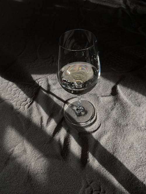 Close-Up Shot of a Wine Glass on the Sand