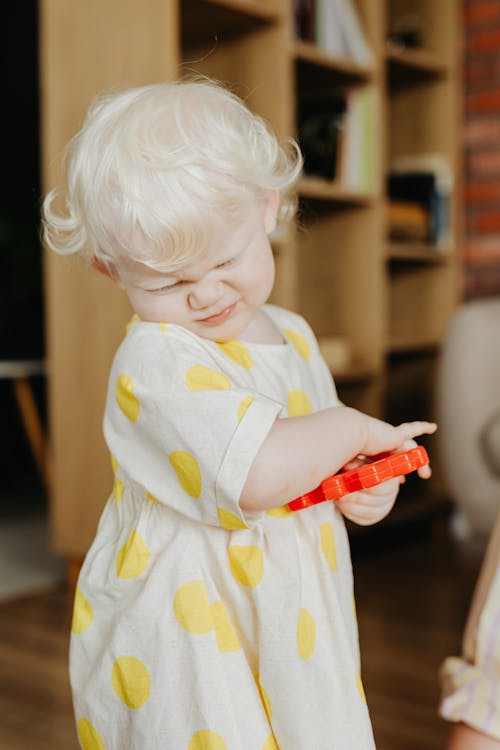 Close-Up Shot of a Cute Baby Girl in Polka Dot Dress