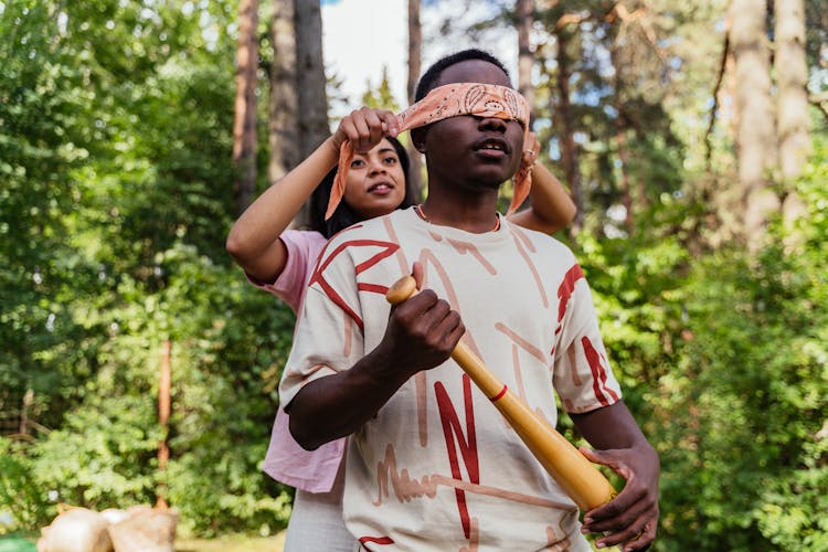 A Woman Covering The Eyes Of A Man Using A Handkerchief