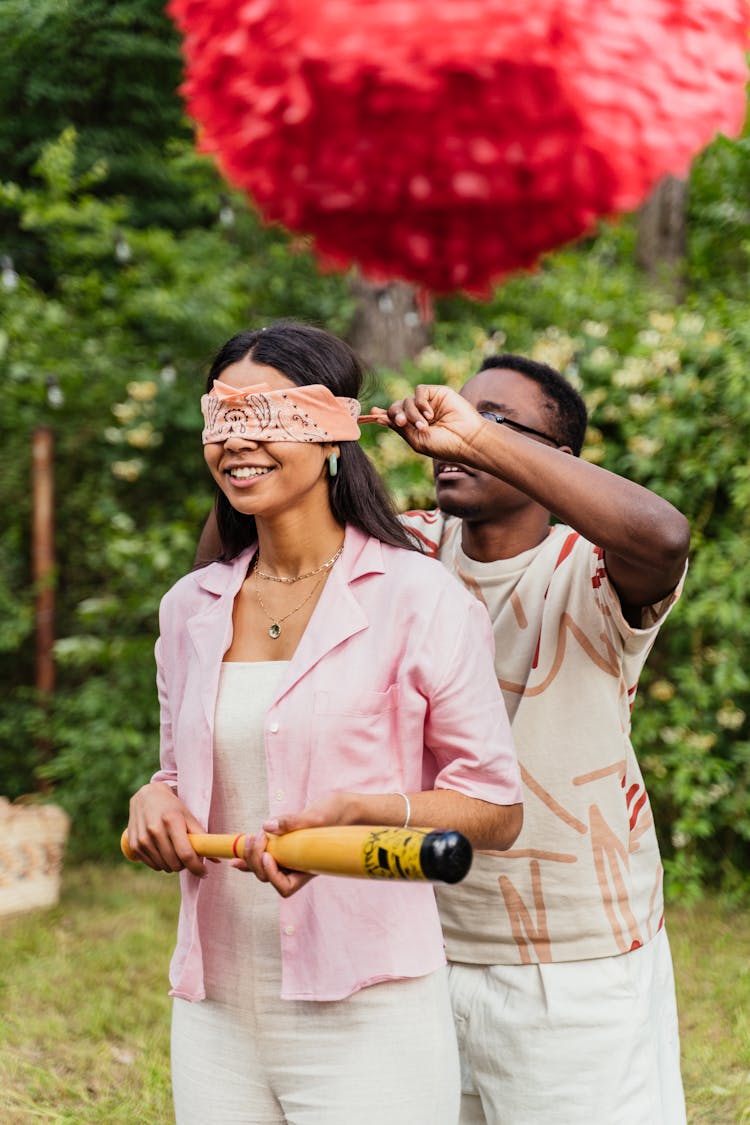 Man Blindfolding Woman At Party