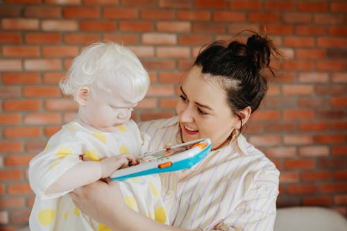 Woman Carrying A Little Girl With A Toy