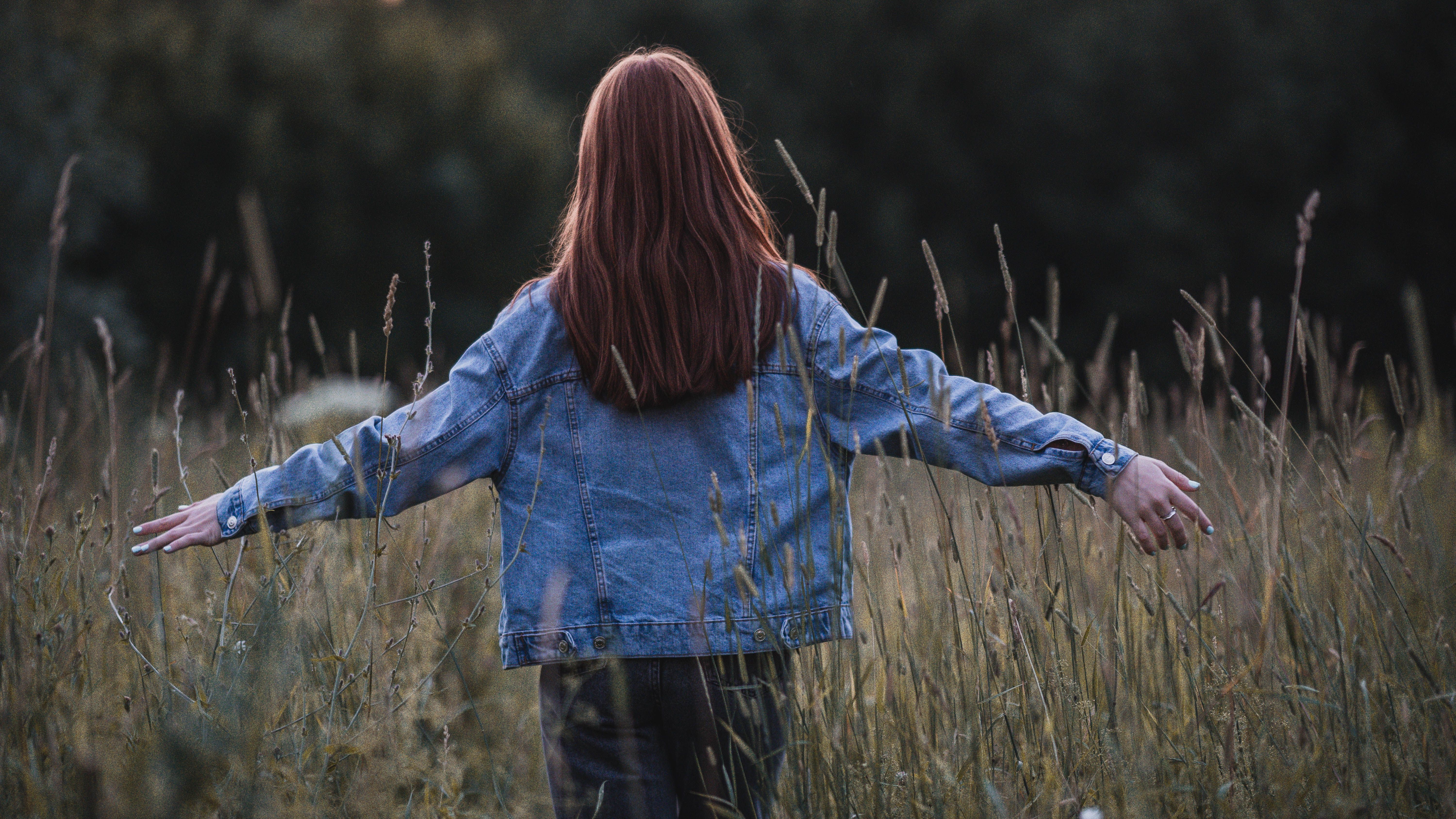 Back View of Woman in Denim Jacket Standing on Grass Field · Free Stock ...