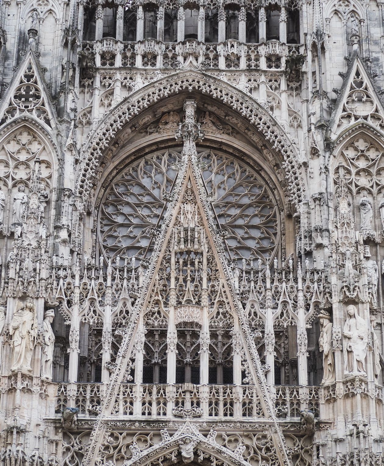 Extremely detailed gothic facade of Rouen Cathedral in Normandy France showing intricate stone carvings and the iconic rose window