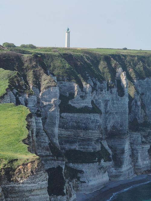 Free Dramatic cliffs in Normandy with a scenic lighthouse under a clear blue sky. Stock Photo