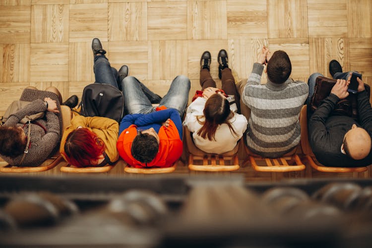 People Sitting In A Row Of Chairs