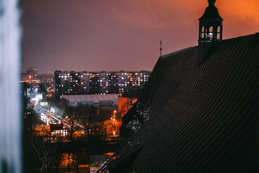 A city rooftop view showcasing illuminated streets and an urban skyline under a night sky.