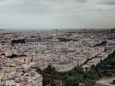 Expansive aerial view of Paris featuring historic Les Invalides amidst a sprawling urban landscape.