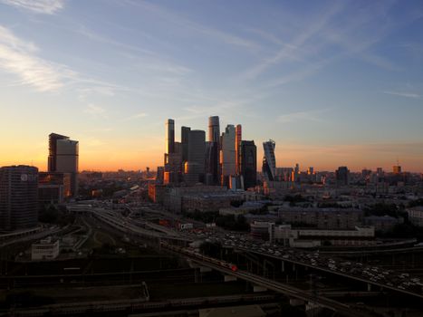 Panoramic view of Moscow City skyscrapers at sunset with a vibrant urban landscape.