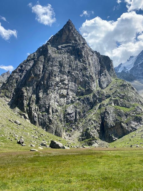 Free Stunning view of a rugged mountain peak surrounded by green landscape under a clear blue sky. Stock Photo