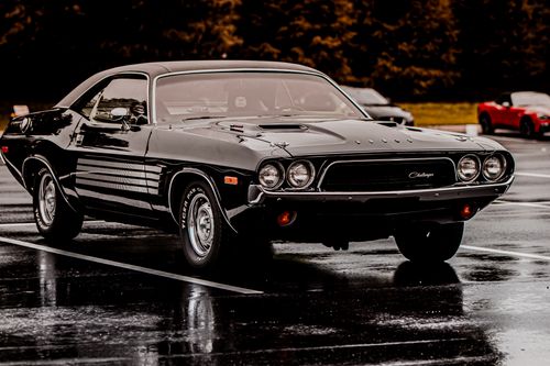 Free Stylish vintage black car parked in a wet outdoor parking lot, showcasing classic automotive beauty. Stock Photo