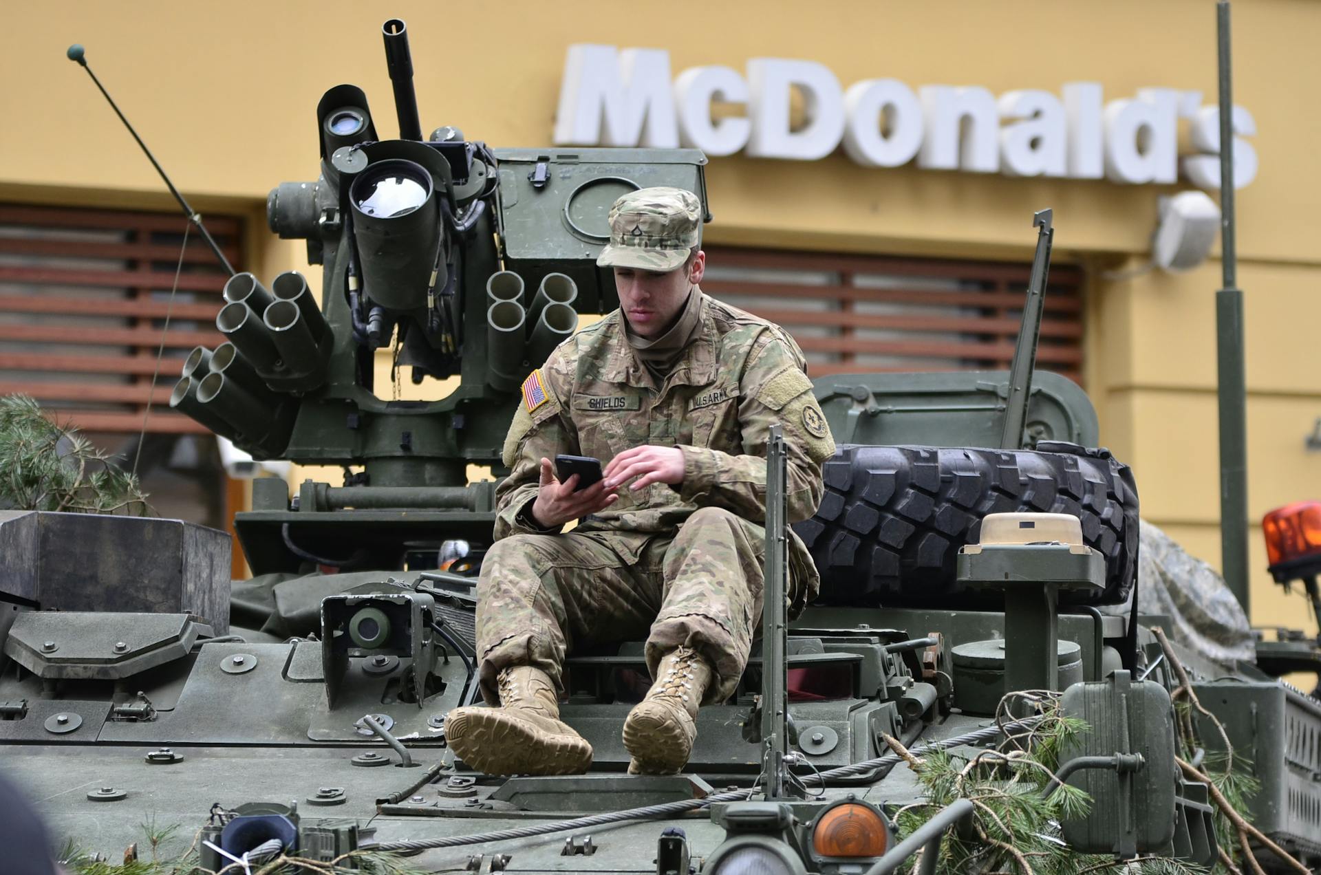 Man In Brown Camouflage Sitting on Top of Tank