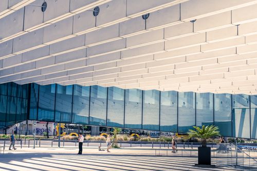 Free Contemporary urban architecture in Lisboa, showcasing reflections and human interaction. Stock Photo