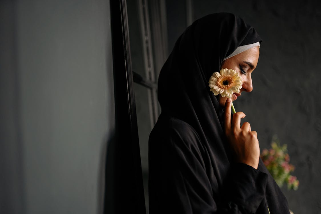 Free Woman in Black Hijab Holding A Flower Stock Photo