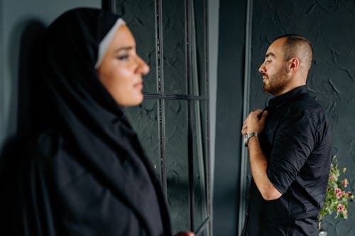 Woman in Hijab and Abaya and Man in Shirt behind