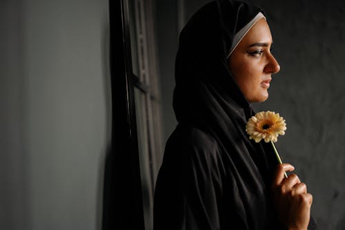 Gratis lagerfoto af fra siden, hijab, holde blomster