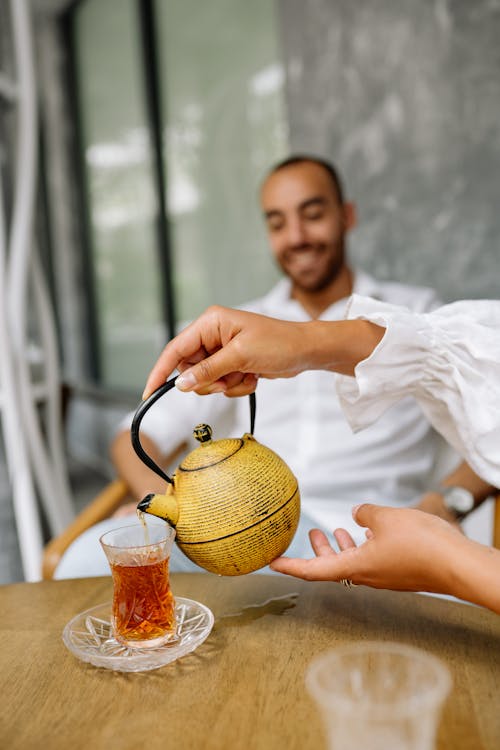 Free A Person Pouring a Tea in a Tea Cup Stock Photo