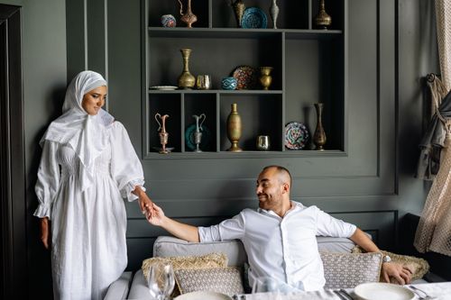 Free Muslim couple sharing a tender moment in a stylish living room setting. Stock Photo