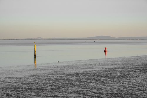 Free Calm sea with buoys and distant horizon at dusk, creating a serene waterfront scene. Stock Photo