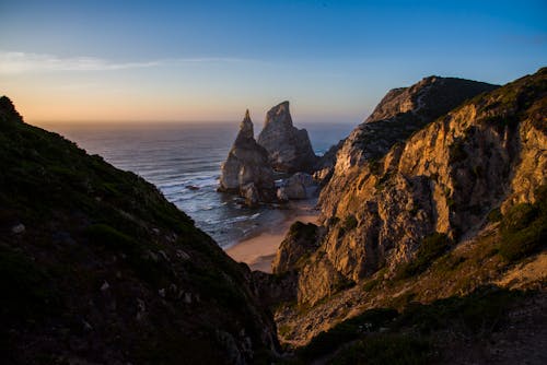 Cliff Rocks near Ocean during Sunset