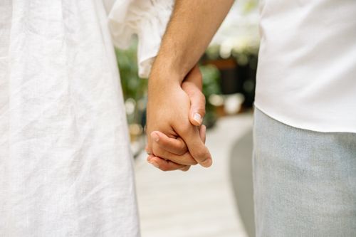 Free Intimate close-up of a couple holding hands, symbolizing romance and connection. Stock Photo