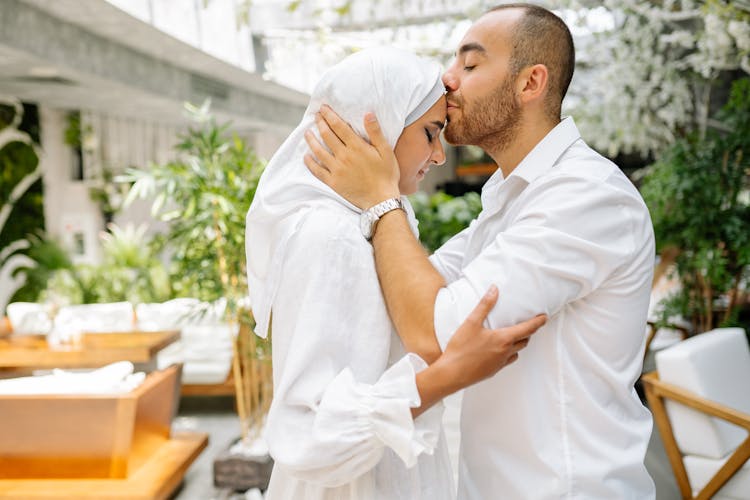 Man Kissing Woman In Forehead