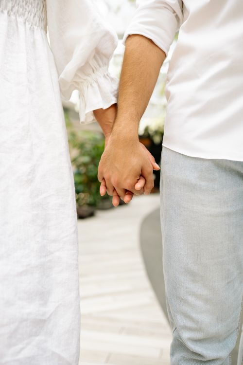 Free Close-up of a couple holding hands in a romantic and serene setting, perfect for themes of love and connection. Stock Photo