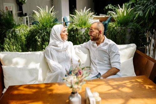 Free Muslim couple sitting in modern green environment, enjoying leisure time together. Stock Photo