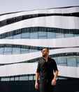 Man in Black Crew Neck T-shirt Standing Near White Concrete Building