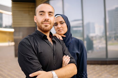 Man in Black Dress Shirt Beside a Woman in Black Hijab