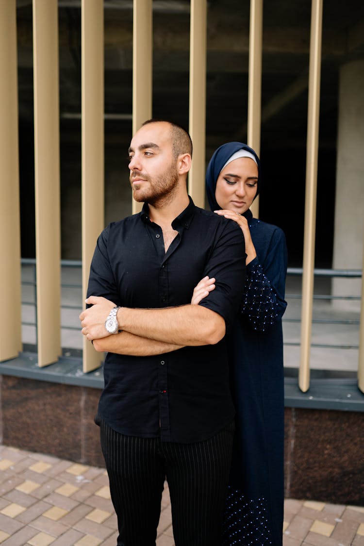 Woman In Blue Hijab Standing At The Back Of The Man