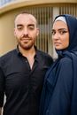 Man in Blue Dress Shirt Beside Woman in Blue Hijab