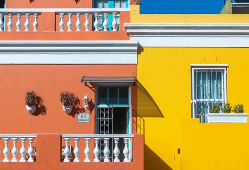 Free Colorful buildings in the Bo-Kaap neighborhood, Cape Town, showcasing vibrant orange and yellow facades. Stock Photo