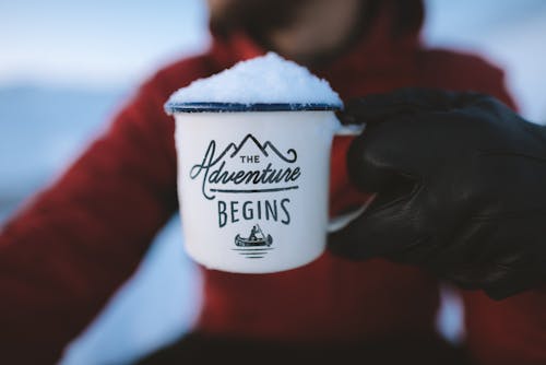 Free Selective Focus Photography of Person Holding the Adventure Begins Mug Stock Photo