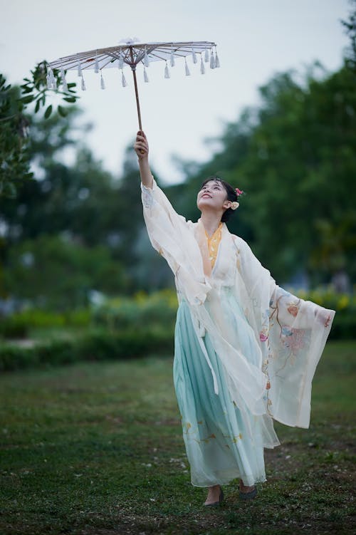 A Woman in Traditional Clothes Holding a Parasol