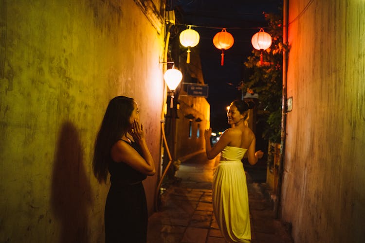 Women Standing On An Alleyway At Night