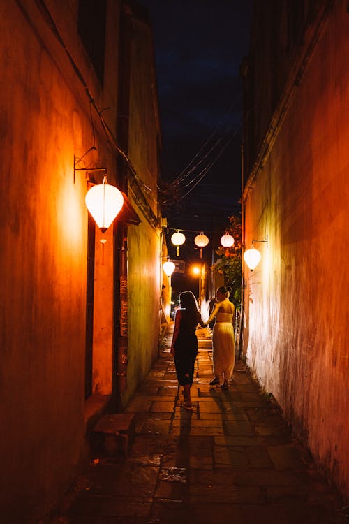 Free Man and Woman Walking on Hallway during Night Time Stock Photo
