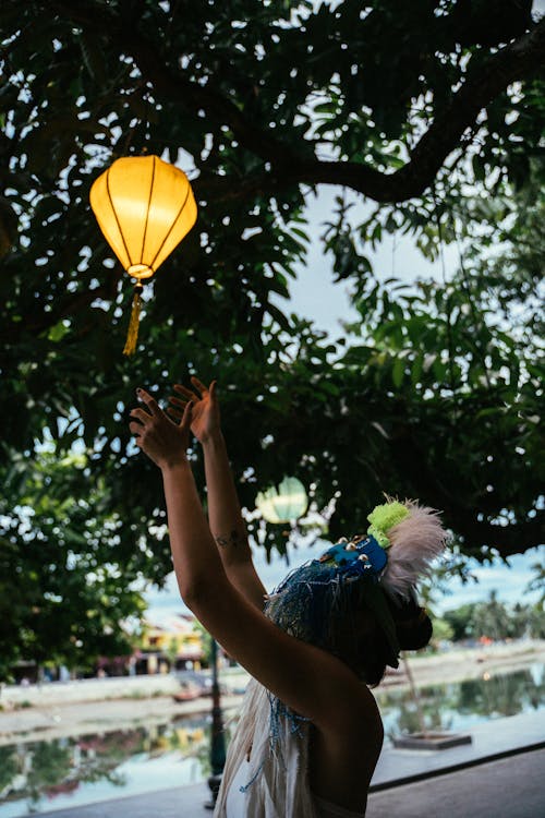 Free A Person in White Shirt Wearing Blue Mask Holding Yellow Lantern Stock Photo