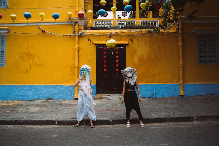 Women Standing Wearing Festival Masks